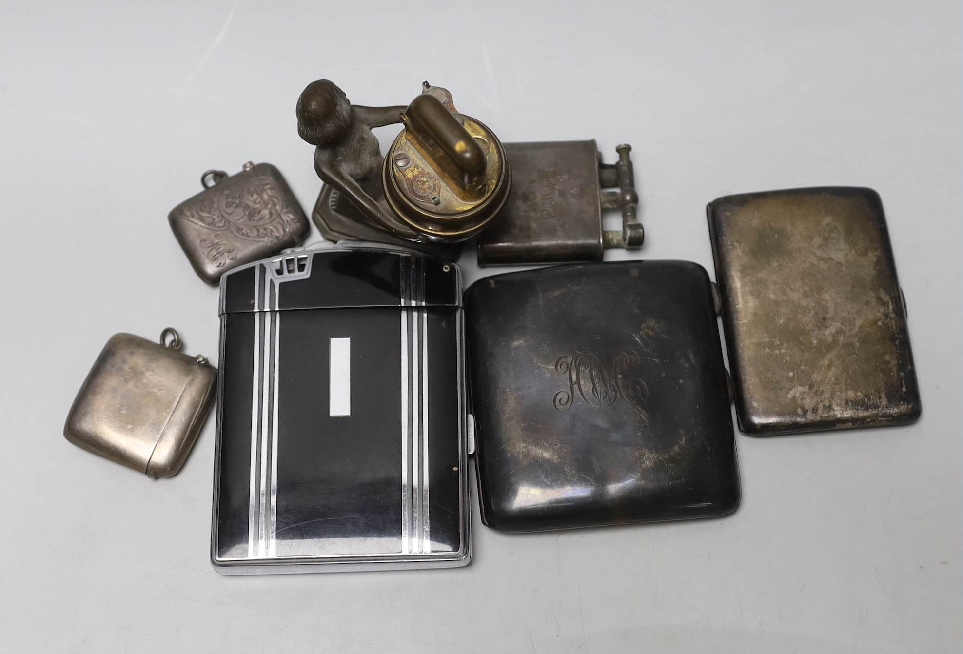 Two silver cigarette cases, two silver vesta cases and three other smoking related items.